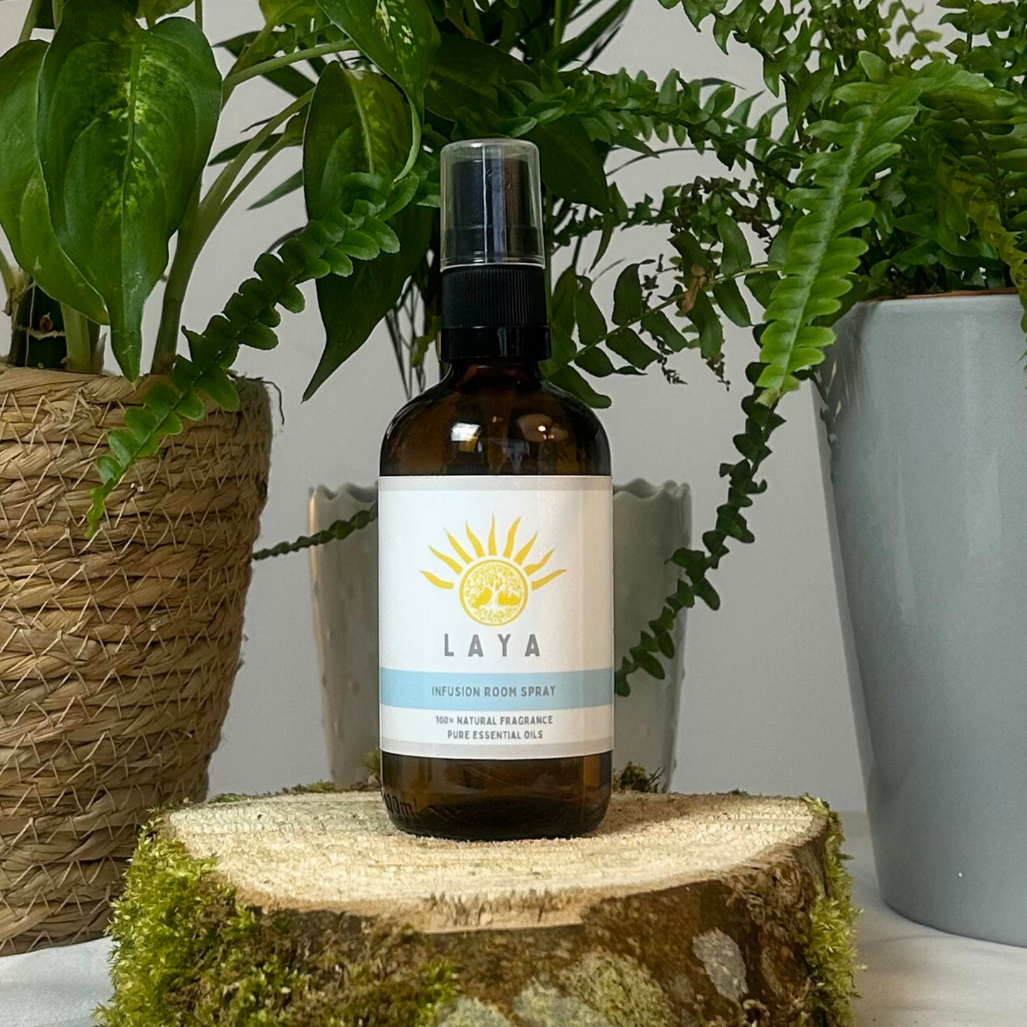 Infusion Room Spray by Laya displayed on natural wood, in 100ml amber glass bottle. 