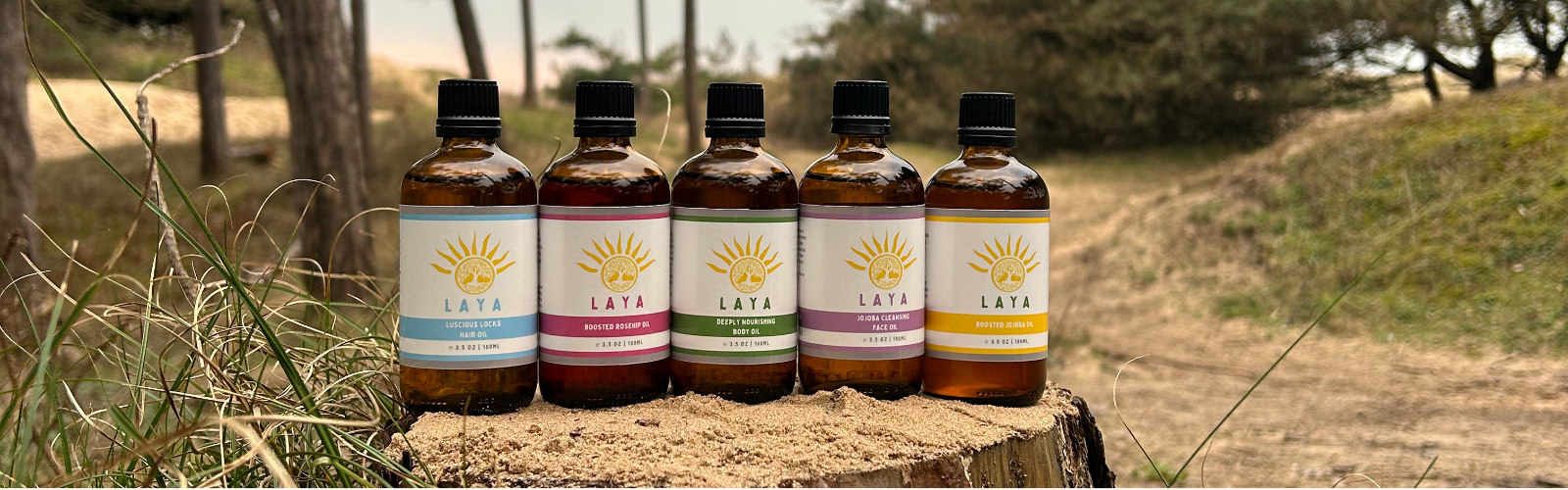 Close-up of five Laya Wellbeing natural oils outdoors, highlighting the diverse selection.